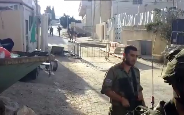 Soldiers at the scene where a soldier was stabbed in Hebron on September 16, 2016 (YouTube screenshot)