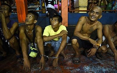 Residents arrested during a drug buy-bust operation wait to be brought to a police station for verification at the former landfill in Manila on September 30, 2016. (AFP PHOTO / TED ALJIBE)
