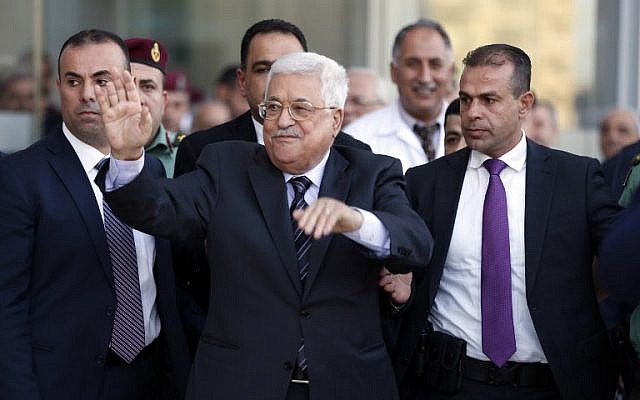 Palestinian Authority President Mahmud Abbas waves as he is escorted out of the Istishari Hospital in the West Bank city of Ramallah on October 6, 2016. (AFP PHOTO / ABBAS MOMANI)