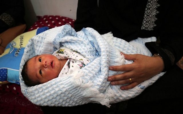 Tahany Shaath holds her three-day old new-born son Waleed at their house in the southern Gaza Strip town of Rafah on October 12, 2016. (AFP/Said Khatib)