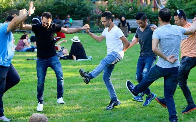 Middle Eastern refugees dance in a Berlin park, summer 2016. (Hillel Zand)