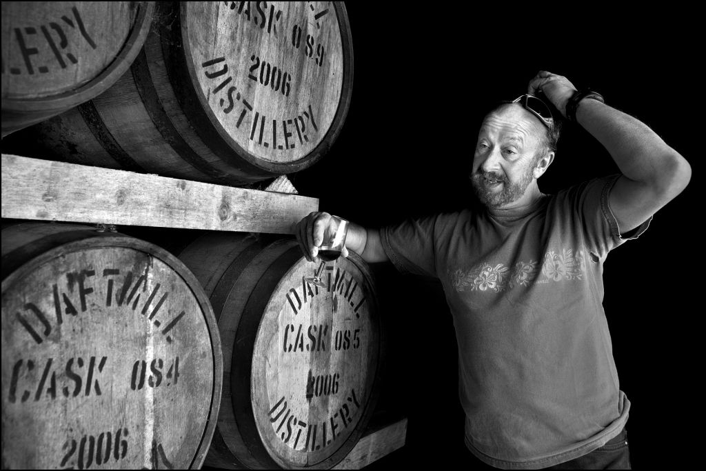 A Jewish whisky analyst leaning on a barrel at a distillery in Fife. (Judah Passow)