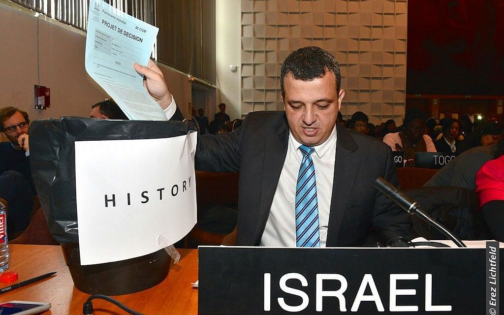 Israel's ambassador to UNESCO Carmel Shama-Hacohen throws a copy of the day's resolution on Jerusalem in the trash, October 26, 2016. (Erez Lichtfeld)