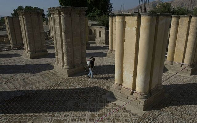 A laborer from the Palestinian Ministry of Tourism and Antiquities works at the site of a 7th century, 827 square meter (8900 square ft) mosaic ahead of the opening ceremony at the Islamic archaeological site of Hisham Palace, in the West Bank city of Jericho, Thursday, Oct. 20, 2016. (AP Photo/Nasser Nasser)