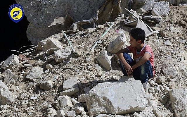 In this picture taken, Tuesday, Oct. 11, 2016, provided by the Syrian Civil Defense group known as the White Helmets, a boy sits amongst rubble in rebel-held eastern Aleppo, Syria. (Syrian Civil Defense - White Helmets via AP)