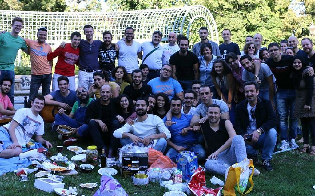 Middle Eastern refugees and IsraAID staff and volunteers at a picnic in a Berlin park, summer 2016. Hillel Zand is in the lower left corner. (Hillel Zand)