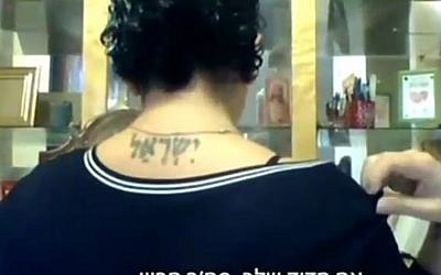 Sandra Solomon shows Channel 2 her tattoo of the word 'Israel' in Hebrew on her upper back. (Screenshot)