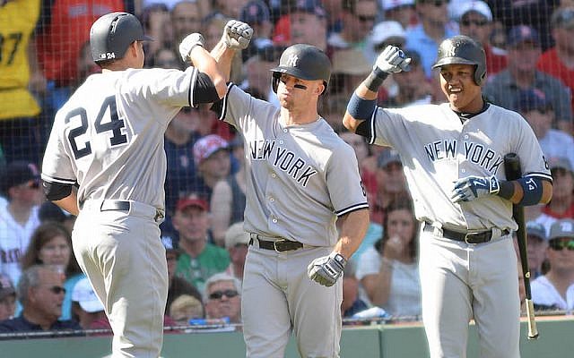 Gary Sanchez, left, high-fiving Yankee teammates Brett Gardner, center, and Starlin Castro at a game against the Red Sox at Fenway Park in Boston, Sept. 17, 2016. (Darren McCollester/Getty Images via JTA)