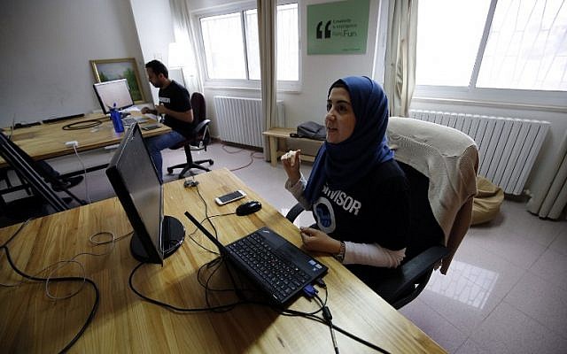Palestinians work at the office of Red Crow, a startup that monitors security developments and sends real-time alerts and maps to clients, in Ramallah on August 17, 2016.  (AFP PHOTO / ABBAS MOMANI)