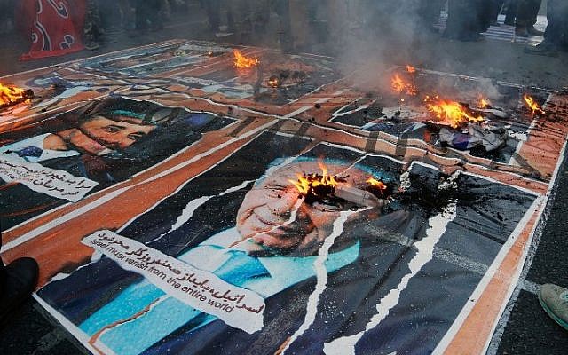 Iranians burn a poster late Israeli president Shimon Peres outside the former US embassy in the Iranian capital Tehran on November 3, 2016. (AFP PHOTO / ATTA KENARE)