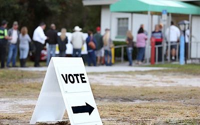 Voters wait in a queue to cast their ballots in the presidential election at a polling station in Christmas, Florida on November 8, 2016. (AFP PHOTO / Gregg Newton)