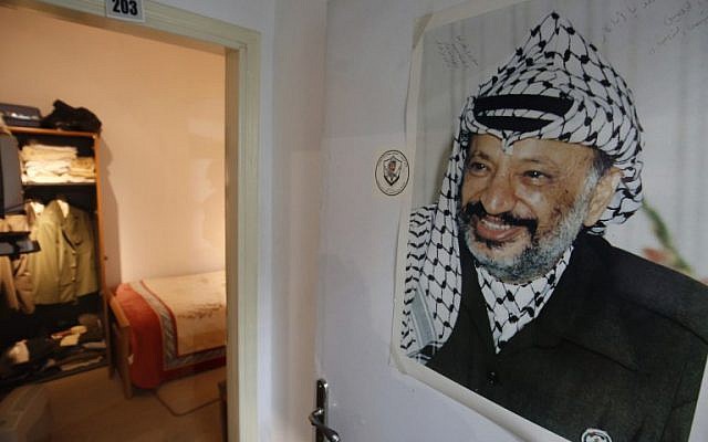A picture taken on November 9, 2016 shows a large printed photograph of late Palestinian leader Yasser Arafat hanging outside a door leading to a recreation of the small bedroom where he spent his final years at the new Arafat Museum in the West Bank city of Ramallah. (AFP/Abbas Momani)