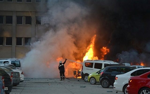 A fireman tries to extinguish burning cars cars after an explosion on November 24, 2016 in Adana, Turkey, in which two people were killed and 16 wounded. (AFP PHOTO/IHLAS NEWS AGENCY)