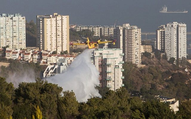 A firefighter plane helps extinguish a fire in the northern Israeli city of Haifa following a wildfire, on November 25, 2016. (AFP PHOTO / MENAHEM KAHANA)