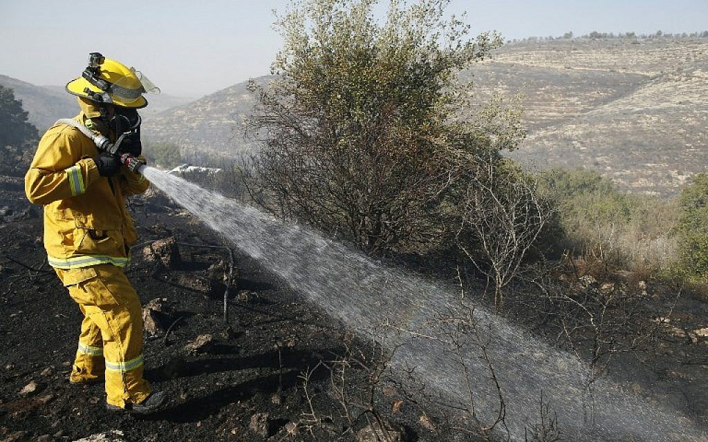 An Israeli firefighter battles the blaze at the village of Nataf, in the Jerusalem hills, on November 26, 2016. (AFP PHOTO/AHMAD GHARABLI)