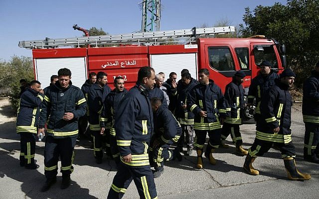 Palestinian firefighters arrive in the Jerusalem hills village of Nataf to help extinguish an ongoing fire in the area, on November 26, 2016. (AFP PHOTO/AHMAD GHARABLI)