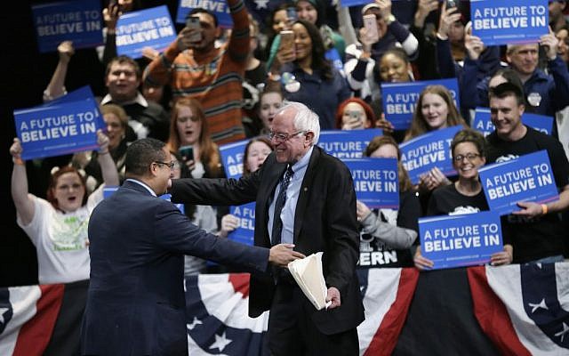 Then-Democratic presidential primary candidate Sen. Bernie Sanders, I-Vermont, is greeted by Rep. Keith Ellison, D-Minnesota, before speaking at a campaign rally, Monday, March 7, 2016, in Dearborn, Michigan. (AP Photo/Charlie Neibergall)