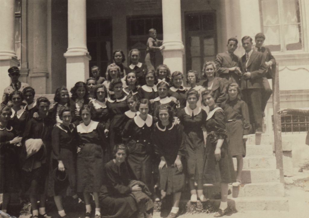 Lena Elias, director Lawrence Russo's mother, in high school in 1938. She is front and center, with a large white collar and her arm around another girl who is leaning down with hands on her knees. (Screenshot)