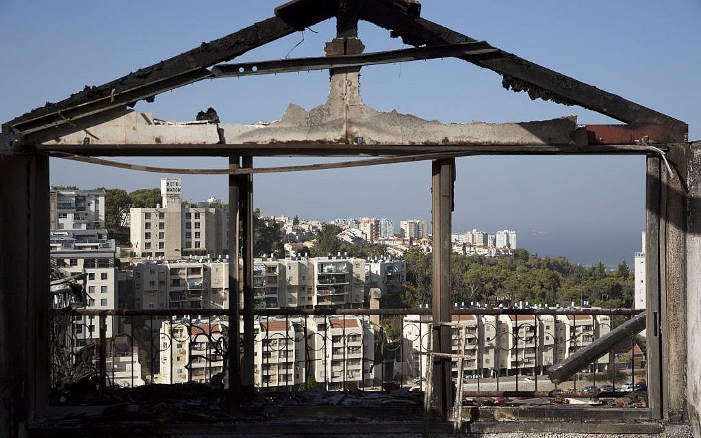 The Mediterranean sea and parts of the city can bee sen through a burned house following wildfires in Haifa, Israel, Friday, Nov. 25, 2016. (AP Photo/Ariel Schalit)