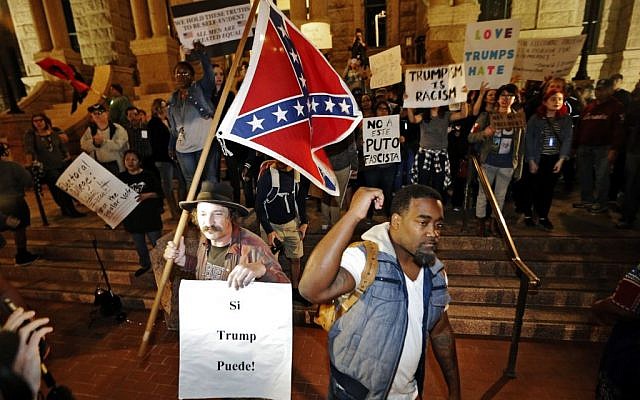 A Trump supporter with a flag, left, counter protests as a small group outside the courthouse protests in opposition of President-elect Donald Trump, Friday, November 11, 2016, in Fort Worth, Texas. (Brandon Wade/Star-Telegram via AP)