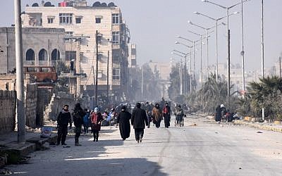 Syrian civilians walk towards a checkpoint manned by pro-government forces, at the al-Hawoz street roundabout, after leaving Aleppo's eastern neighborhoods on December 10, 2016. (AFP PHOTO / George OURFALIAN)