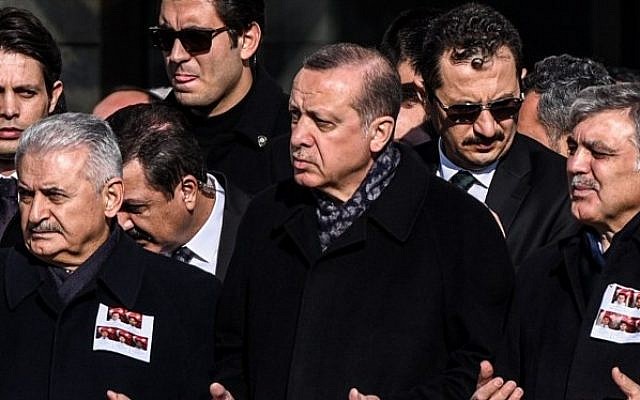 Turkish President Recep Tayyip Erdogan, center, Prime Minister Binali Yildirim, left, and former president Abdullah Gul, right, pray at a funeral ceremony for police officers killed at Istanbul's police headquarters on December 11, 2016. (AFP Photo/Ozan Kose)