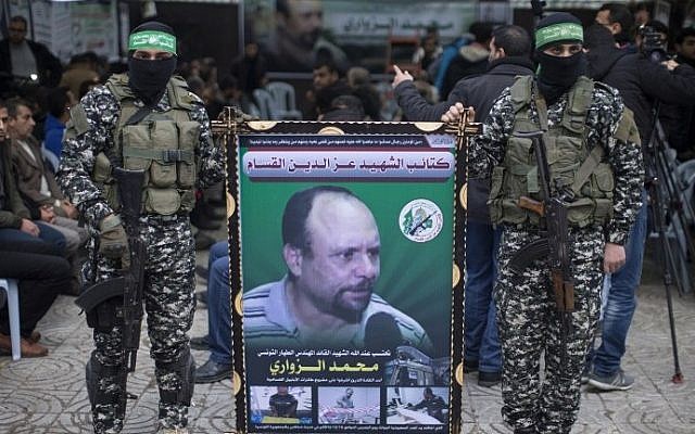 Members of the Izz ad-Din al-Qassam Brigades, the military wing of Hamas, hold a banner bearing a portrait of Mohammed al-Zoari in Gaza City on December 18, 2016. (AFP/Mahmud Hams)