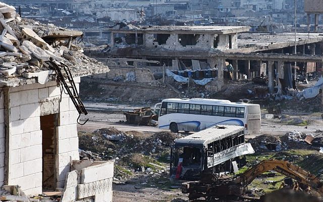 A bus drives through the government-controlled crossing of Ramoussa, on the southern outskirts of Aleppo, on December 18, 2016, during an evacuation operation of rebel fighters and civilians from rebel-held areas. (AFP/George OURFALIAN)