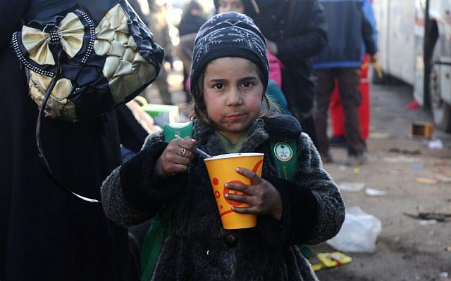 A Syrian girl, who was evacuated from the last rebel-held pockets of Syria's northen city of Aleppo, eats upon arriving on December 20, 2016 in the opposition-controlled Khan al-Assal region, west of the embattled city. (AFP PHOTO / Baraa Al-Halabi)