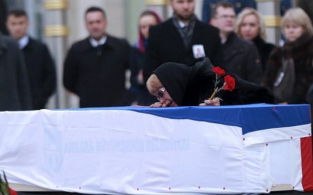 Marina Davydova Karlova, widow of late Russian Ambassador to Turkey Andrei Karlov, reacts in front of his coffin, during a ceremonial farewell with full state honours on the tarmac of Ankara's Esenboga Airport on December 20, 2016, before the coffin is transported on a Russian plane for Moscow. (AFP PHOTO/ADEM ALTAN)