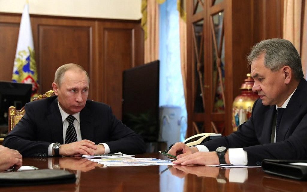 Russian President Vladimir Putin (left) speaks with Defense Minister Sergey Shoigu during a meeting at the Kremlin in Moscow on December 29, 2016. (AFP PHOTO/Sputnik/Michael Klimentyev)