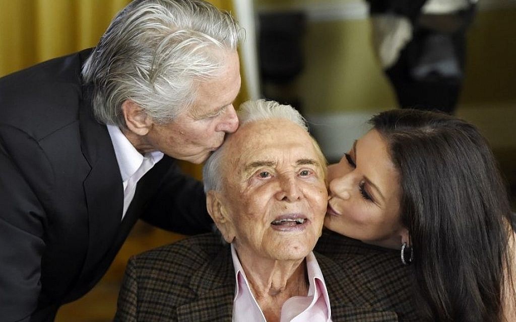 Actor Kirk Douglas, center, gets a kiss from his son Michael Douglas, left, and Michael's wife Catherine Zeta-Jones during his 100th birthday party at the Beverly Hills Hotel on Friday, Dec. 9. 2016, in Beverly Hills, Calif. (Chris Pizzello/Invision/AP)