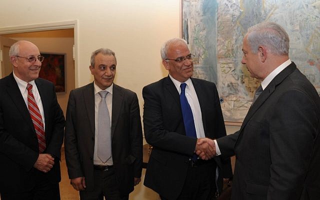Prime Minister Benjamin Netanyahu shakes hands with Saeb Erekat in Jerusalem, April 2012. Netanyahu aide Yitzhak Molcho is at left, and PA security chief Majed Faraj is at second left. (Amos Ben Gershom /GPO/Flash90)