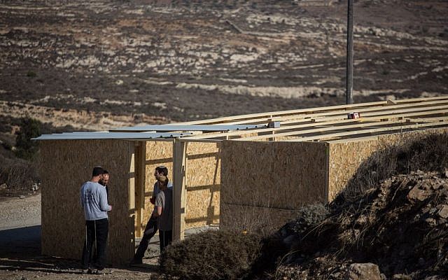 Young Israeli men build a structure in the West Bank outpost of Amona on November 28, 2016. The structure is meant to house supporters for when the state decides to evacuate the outpost, which was built on private Palestinian land. (Hadas Parush/Flash90)