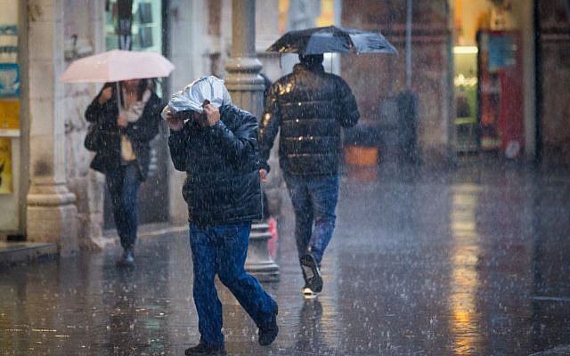 People walk in the rain on Jaffa Street in downtown Jerusalem on December 1, 2016, as the first storms of the winter season hit the country. (Photo by Yonatan Sindel/Flash90)