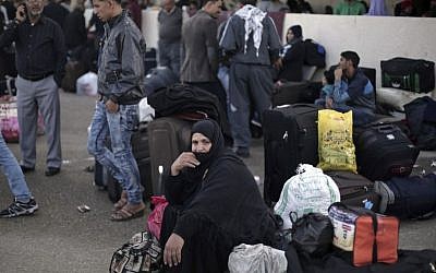 Illustrative photo of Palestinian woman who sits next to her luggage as she waits to cross to the Egyptian side of the Rafah border crossing, in Rafah, Gaza Strip, October 19, 2016. (AP Photo/Adel Hana, File)