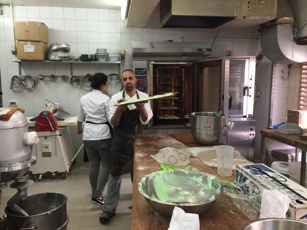 In the upstairs kitchen at Kadosh, where trays of pistachio meringues make their way in and out of the oven (Jessica Steinberg/Times of Israel)