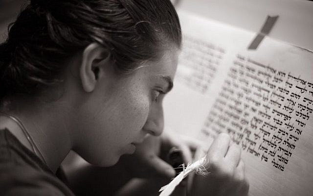 Illustrative: a woman scribing the Megillat Esther. (Courtesy)