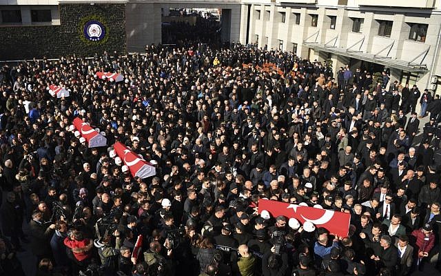 Coffins of bomb victims are carried through the crowd during a memorial in Istanbul, Sunday, December 11, 2016, for police officers killed outside the Besiktas football club stadium Vodafone Arena late Saturday. (AP)