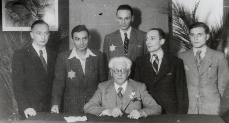 Mordechai Chaim Rumkowski and other officials pose for a group portrait in the Jewish Council's headquarters, Lodz Ghetto, January 1941 (US Holocaust Memorial Museum, courtesy of Judith M. Shaar)