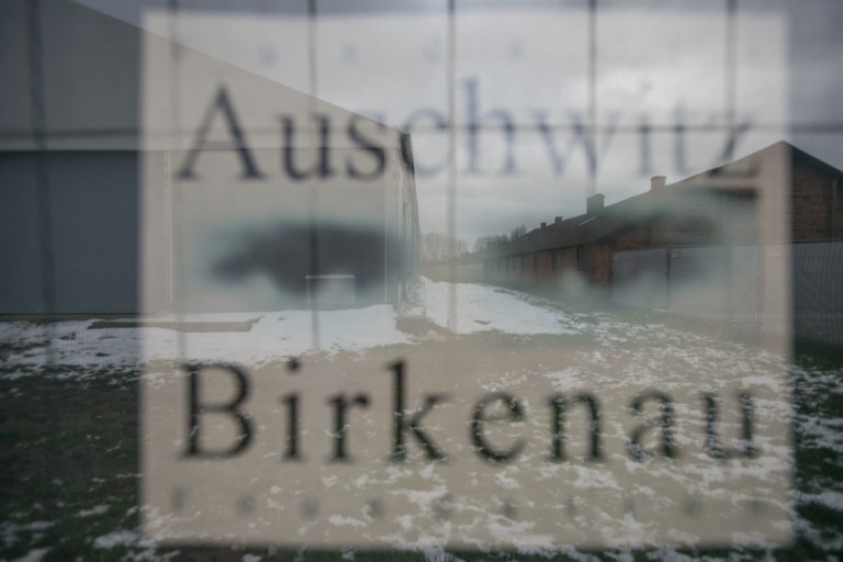 Barracks are seen through a poster at the former Nazi concentration camp in Oswiecim (Auschwitz), Poland, on December 2, 2016. (AFP PHOTO / BARTOSZ SIEDLIK)