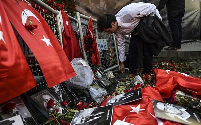 A man lays flowers in front of the Reina nightclub on January 3, 2017, in Istanbul, after a gunman killed 39 people on New Year's night.  AFP/BULENT KILIC)
