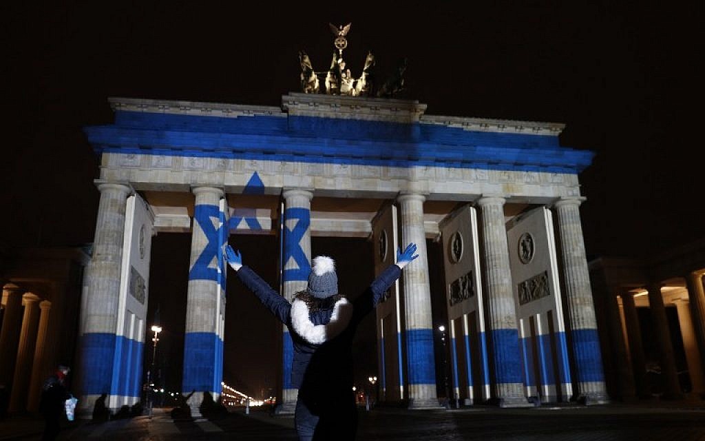 A woman strikes a pose in front of the Brandenburg Gate with the Israeli flag projected onto in Berlin, on January 9, 2017, to pay tribute to the victims of the ramming attack in Jerusalem. (AFP PHOTO / Odd ANDERSEN)