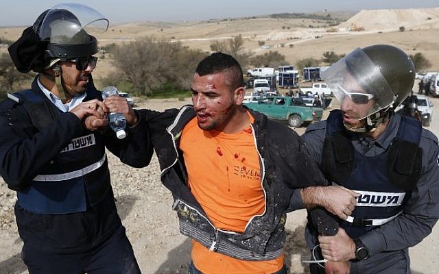 Israeli policemen detain a Bedouin man during a protest against home demolitions on January 18, 2017, in the unrecognized Bedouin village of Umm al-Hiran in the Negev desert. (AFP Photo/Ahmad Gharabli)