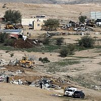 Israeli policemen stand guard as bulldozers demolish homes in the unrecognized Bedouin village of Umm al-Hiran in the Negev desert, on January 18, 2017. (AFP Photo/Menahem Kahana)