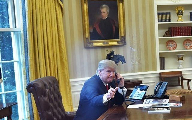US President Donald Trump, left, seen through an Oval Office window, speaks on the phone to King Salman of Saudi Arabia in the Oval Office of the White House in Washington, DC on January 29, 2017. (AFP/ Mandel Ngan)