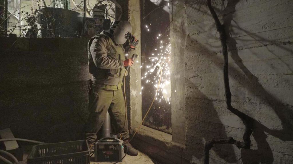 An IDF soldier welds shut a workshop suspected of being used to manufacture illegal guns in Hebron on January 30, 2017. (IDF Spokesperson's Unit)