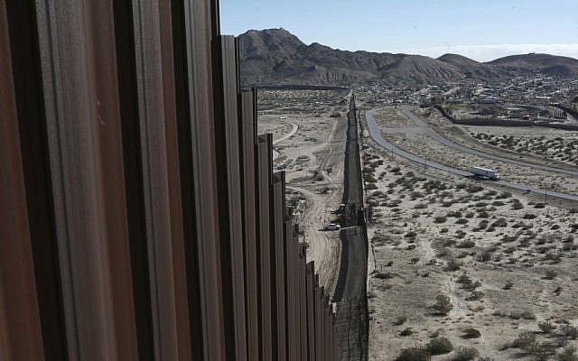 A truck drives near the Mexico-US border fence, on the Mexican side, separating the towns of Anapra, Mexico and Sunland Park, New Mexico, Wednesday, Jan. 25, 2017. (AP/Christian Torres)