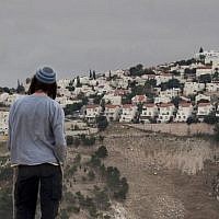 A Jewish settler looks at the West Bank settlement of Ma'ale Adumim, from the E-1 area on the eastern outskirts of Jerusalem, on December 5, 2012. (AP Photo/Sebastian Schooner/File)