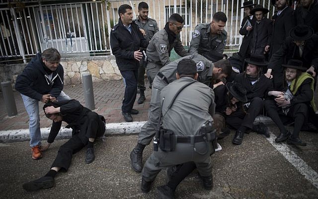 Ultra-Orthodox Jewish men clash with police during a protest against the arrest of a Jewish seminary students who failed to comply with a recruitment order, next to the army recruiting office in Jerusalem, January 4, 2017. (Yonatan Sindel/Flash90) 